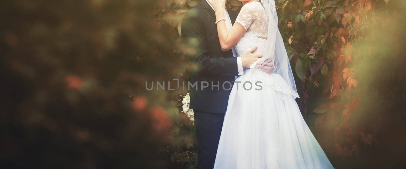 bride and groom hold hands at sunset