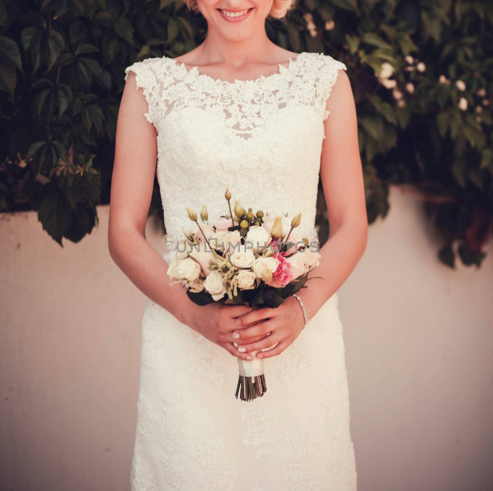 portrait of a happy bride with a bouquet of flowers outdoors
