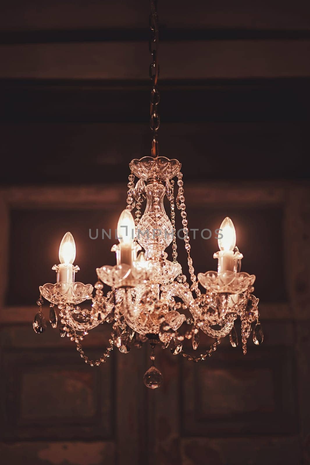 Crystal chandelier lamp on the ceiling. Image in a luxury tone