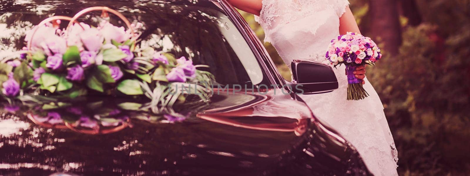 a bride with a bouquet on the background of a decorated wedding car
