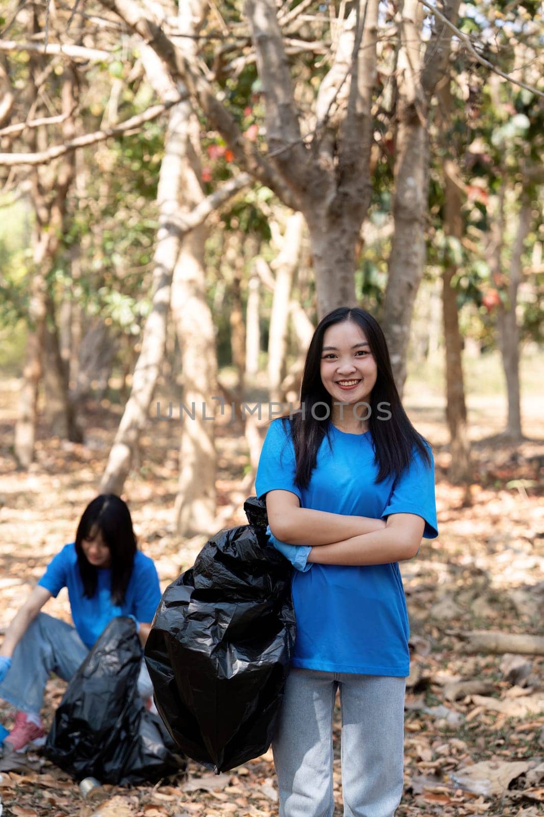 Volunteer collecting plastic trash in the forest. The concept of environmental conservation. Global environmental pollution. Cleaning the forest by nateemee