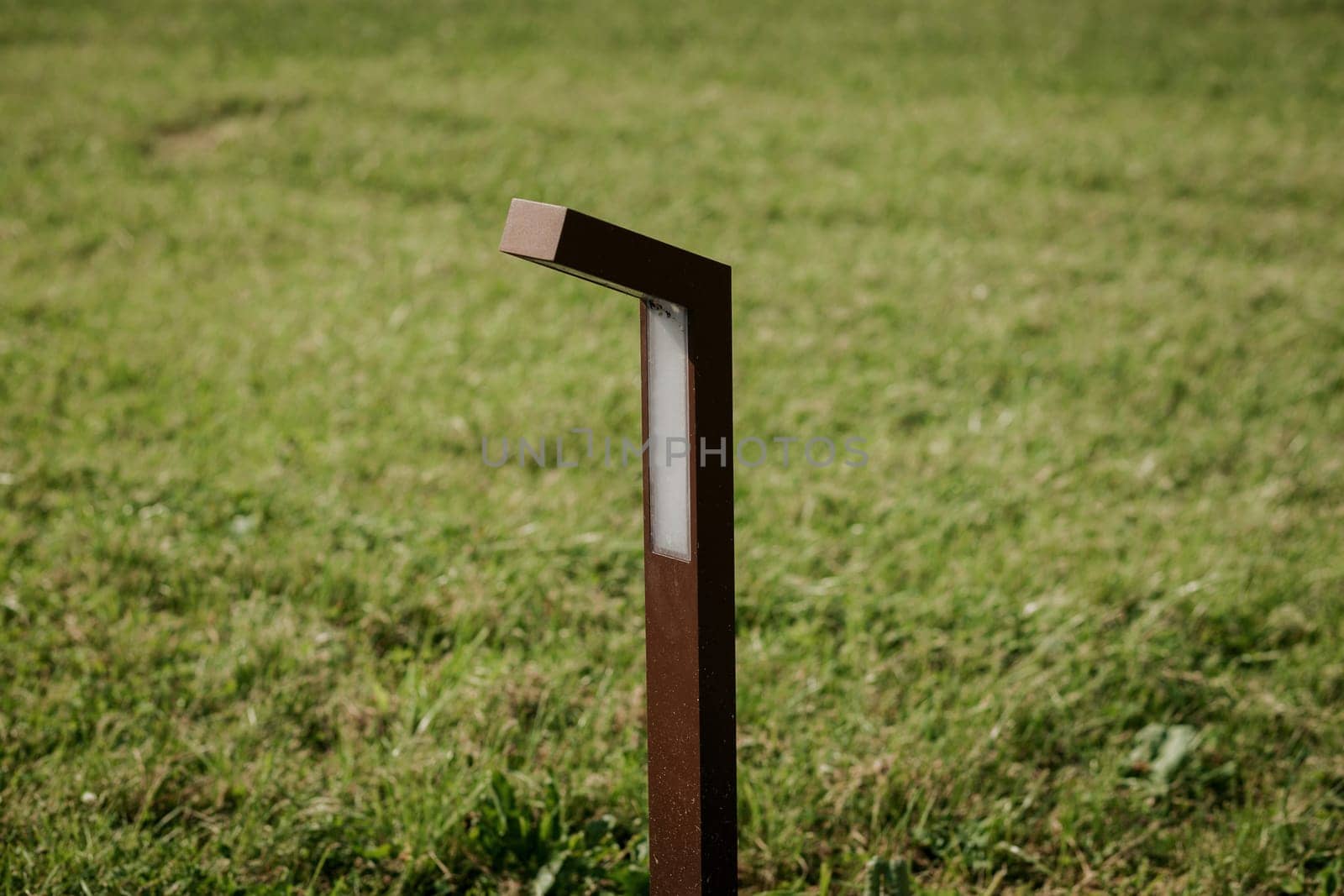 modern ground lantern in a park with a green lawn, a close-up lantern.