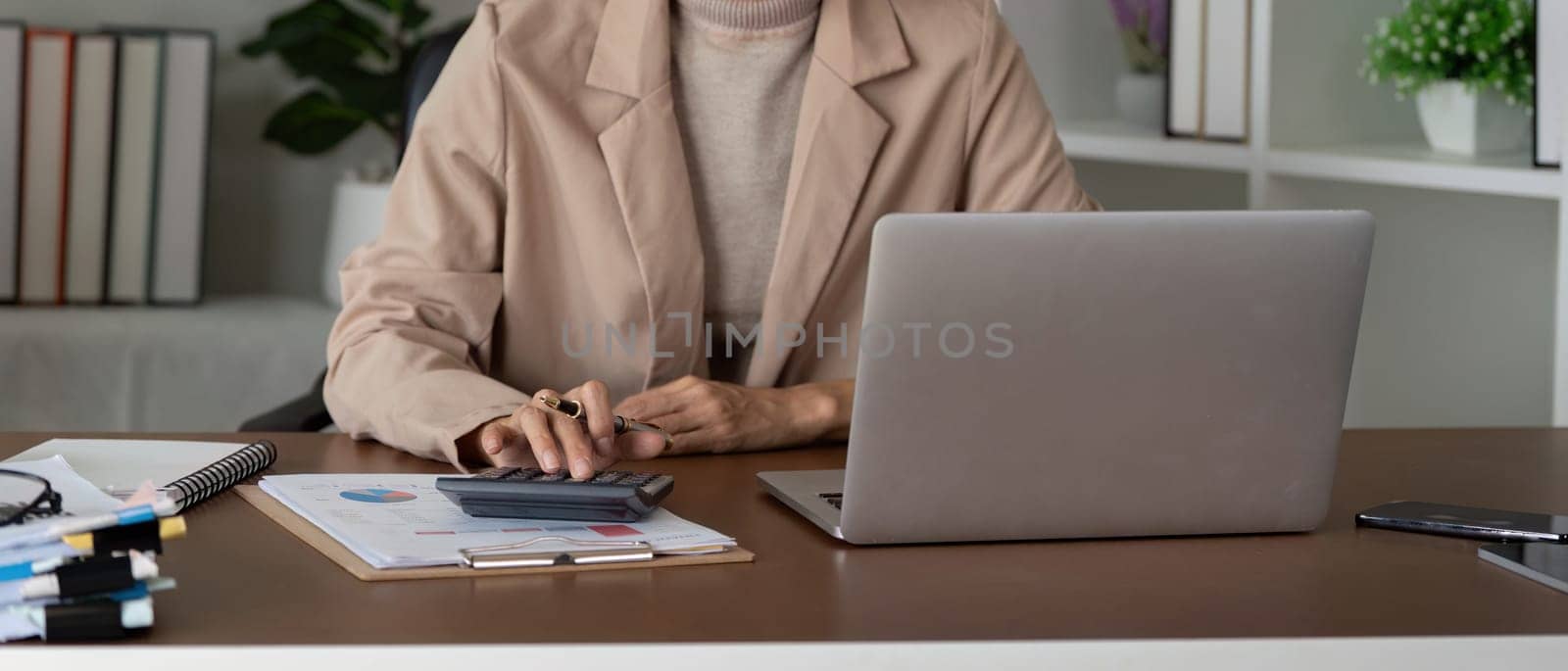 Close up business woman hand analyze to calculate the company financial and tax results the office, accounting, statistics, and analytical research.