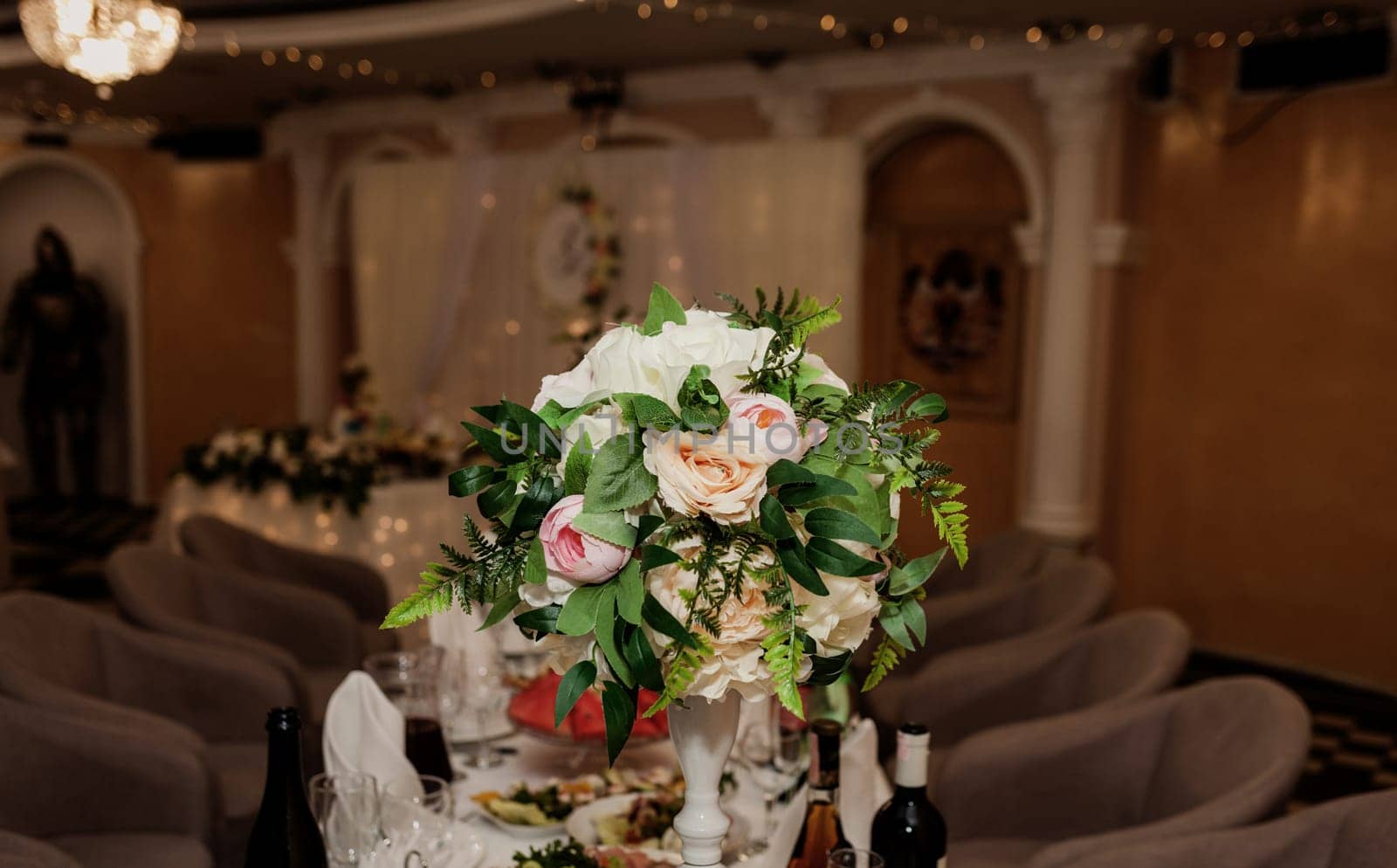 table set for dinner with flower composition in restaurant, luxury interior background. Wedding elegant banquet decoration