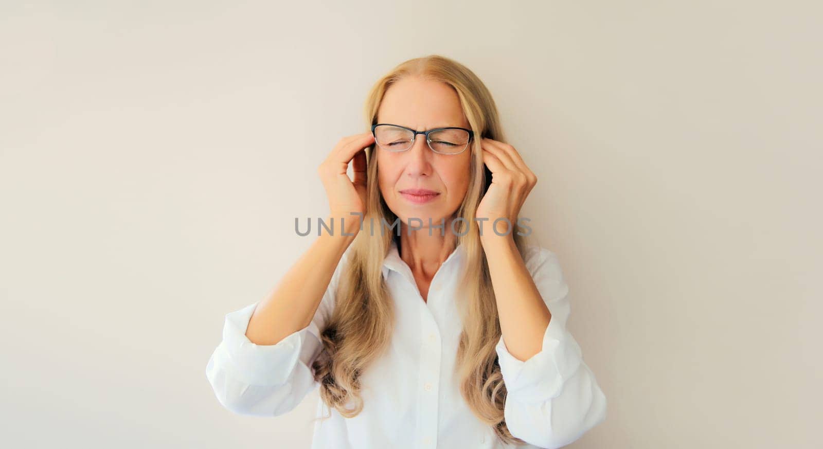 Exhausted tired caucasian middle-aged woman employee with headache or temples pain, suffers from migraine, tension in the head at home