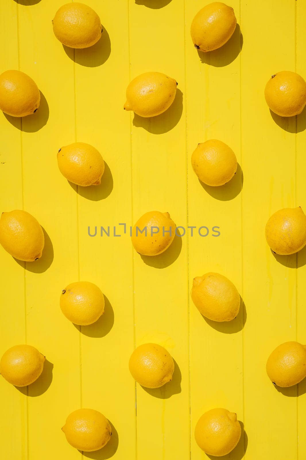 Many lemons on bright yellow background. Lemon fruit, citrus minimal concept, vitamin C. Creative summer concept