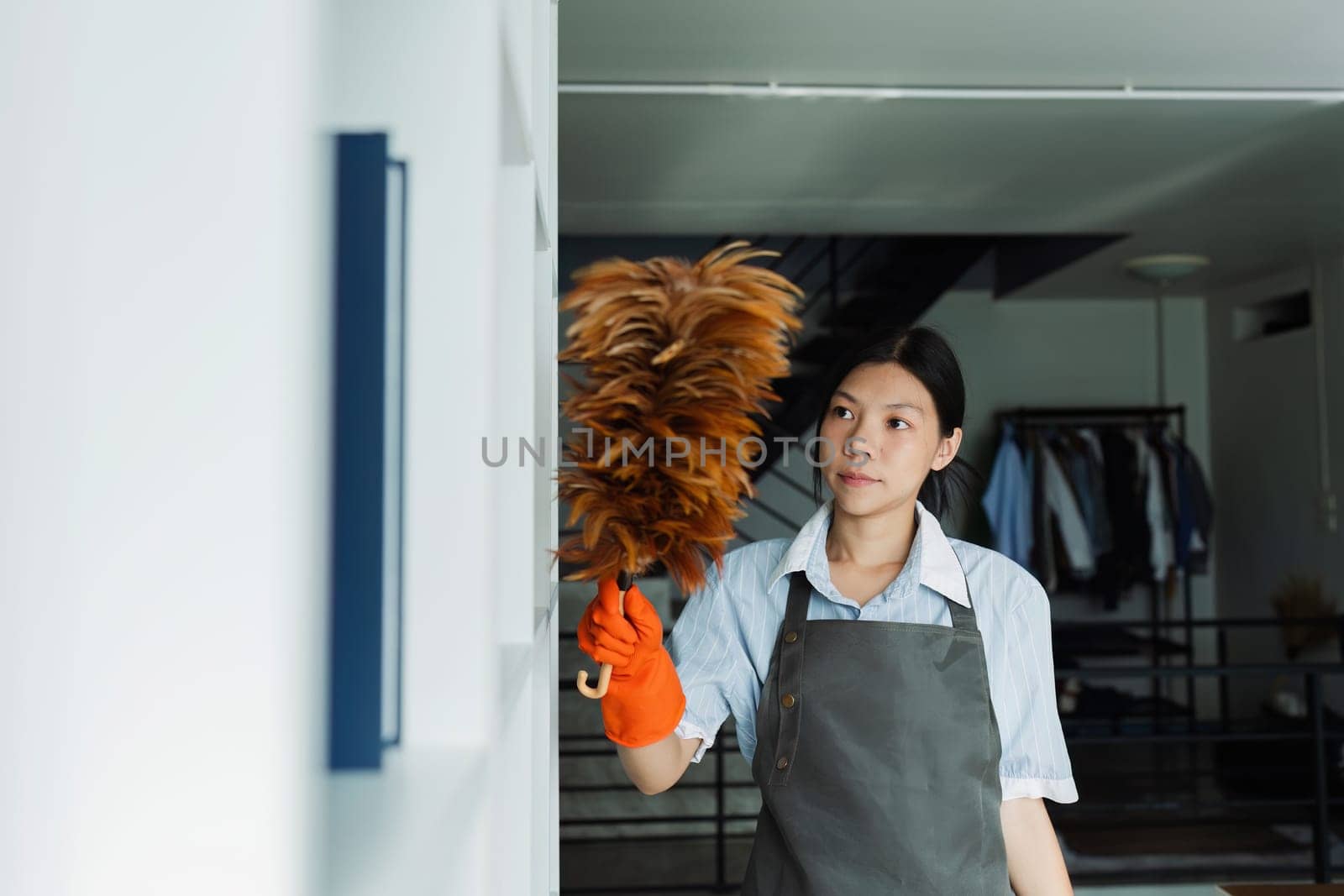 Female housekeeper smile and wearing glove, preparing to clean office.