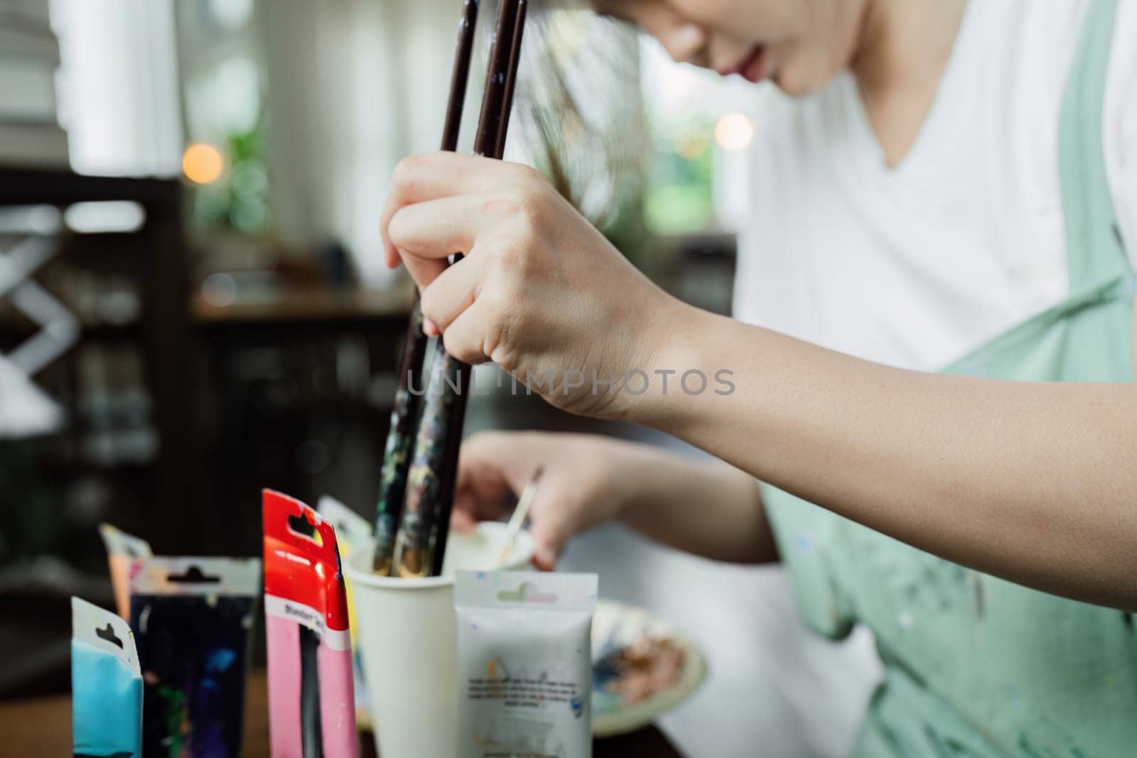 A beautiful young woman artist working on painting something on a large canvas by itchaznong