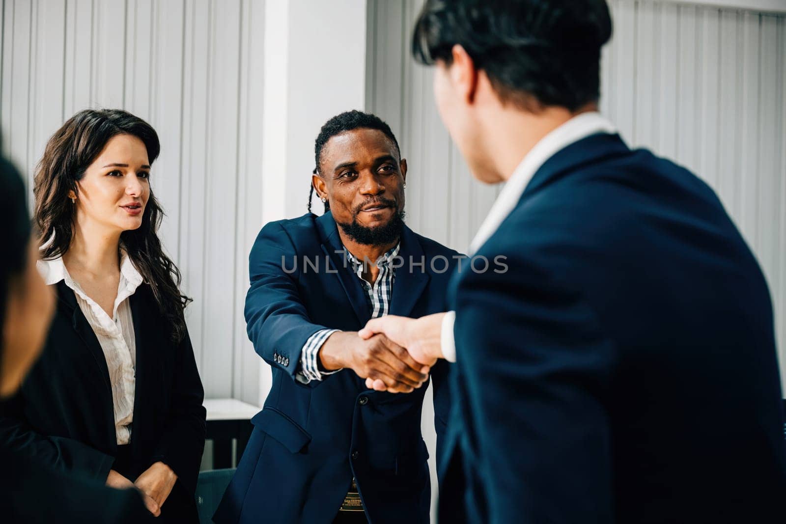 Close-up of a handshake between a young manager and a new employee, symbolizing success and collaboration in their business partnership. Men shake hands during a leadership meeting.
