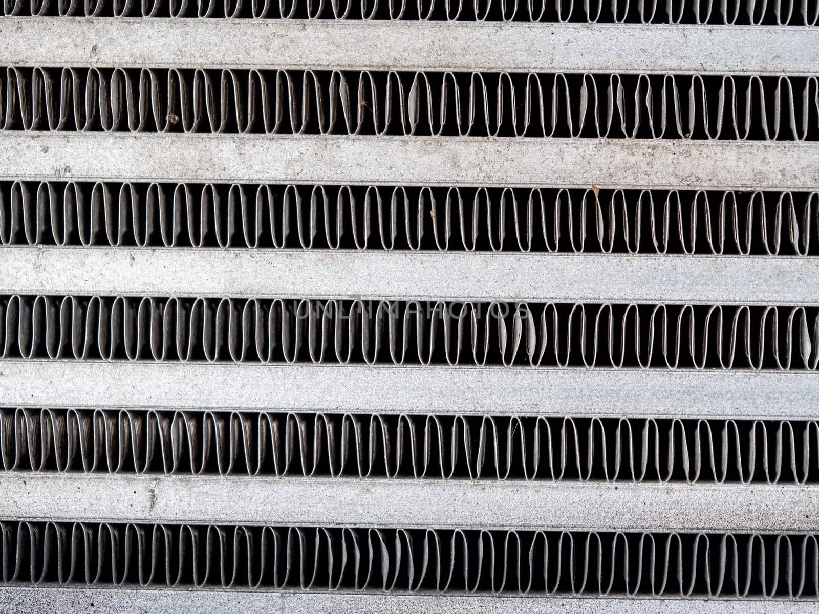 The metal grill of a car radiator is old and has scale marks by Satakorn