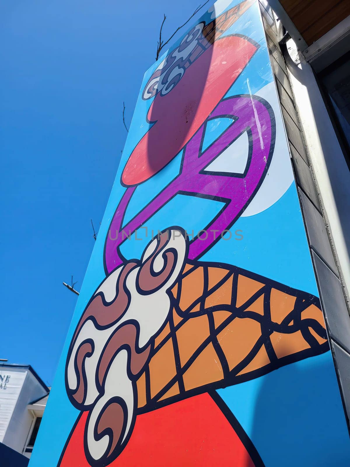 Vibrant mural of a playful ice cream cone on a restaurant in San Francisco, symbolizing urban renewal and creativity, 2023