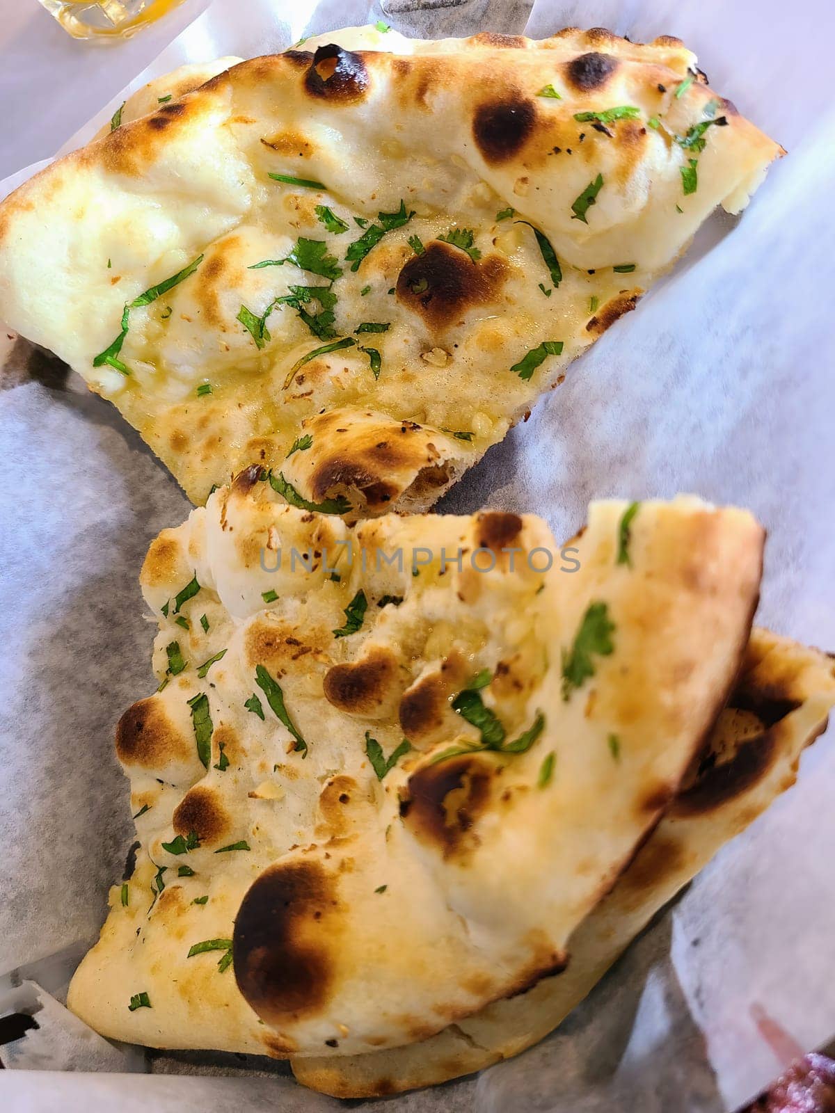 Freshly baked naan bread sprinkled with cilantro in an Indianapolis, Indiana restaurant, showcasing traditional Indian cuisine in 2023