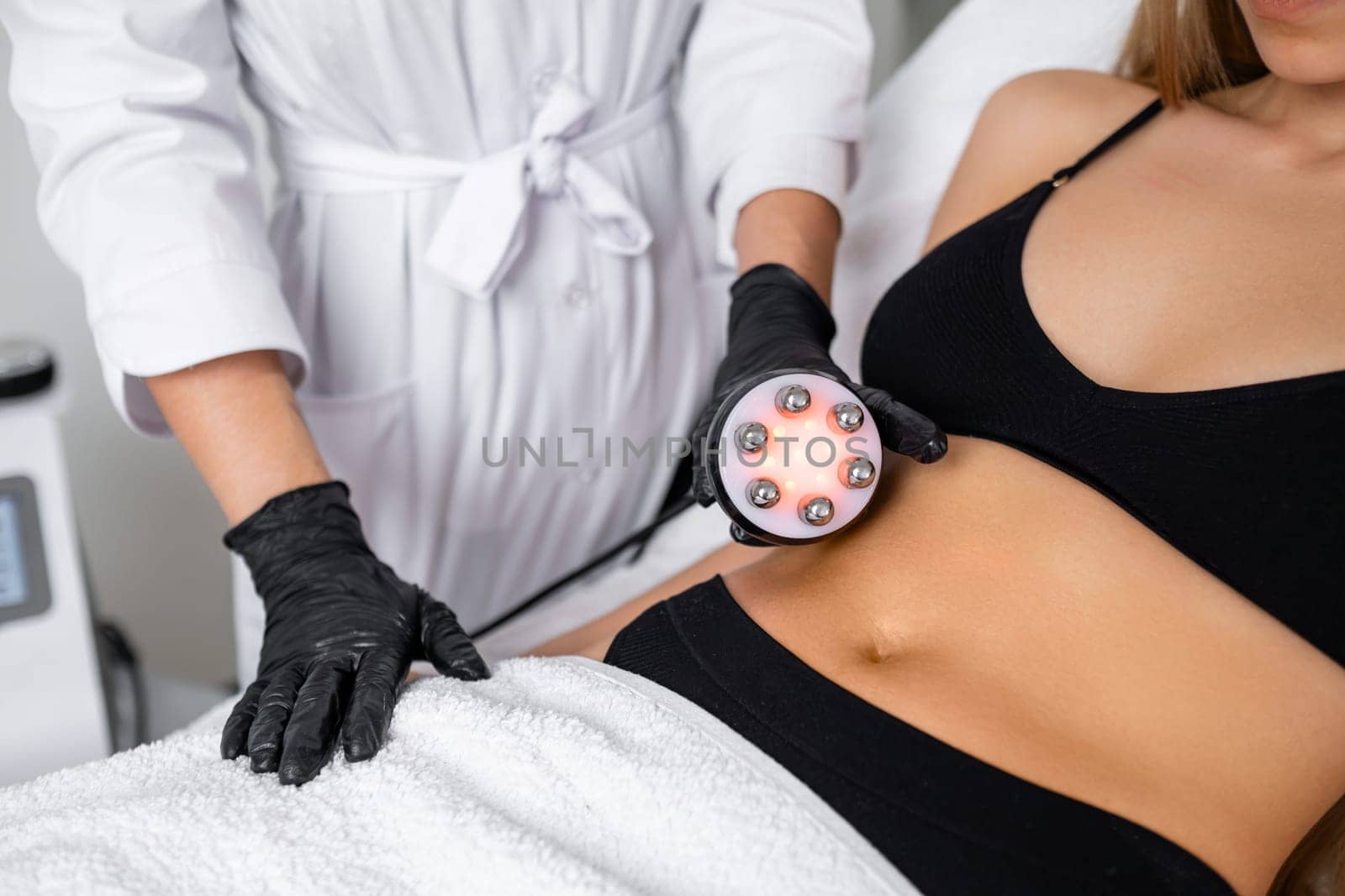Belly fat reduction is the focus as a young woman undergoes RF body cavitation lifting at the beauty salon.
