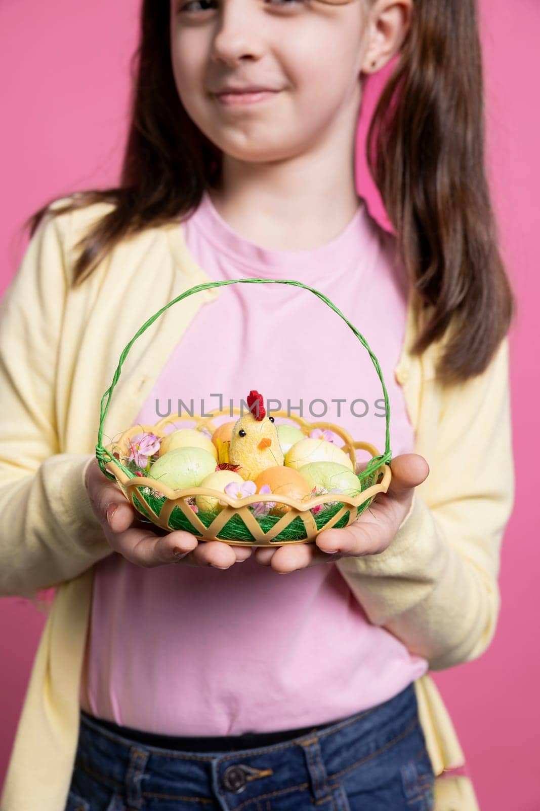 Beautiful small girl with bunny ears holding an egg basket for easter festivity by DCStudio