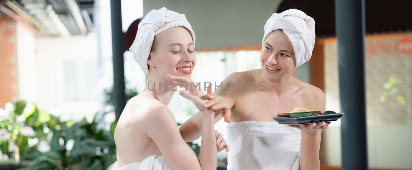 Two attractive woman in towel giggling during hold the herbal bowl. Tranquility. by biancoblue