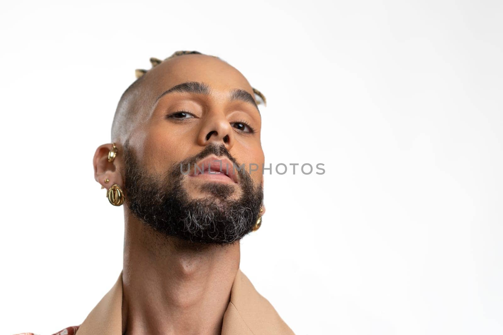 Studio close-up portrait handsome black gay man looking at camera. Seductive sexy man, transgender person isolated on white. LGBT