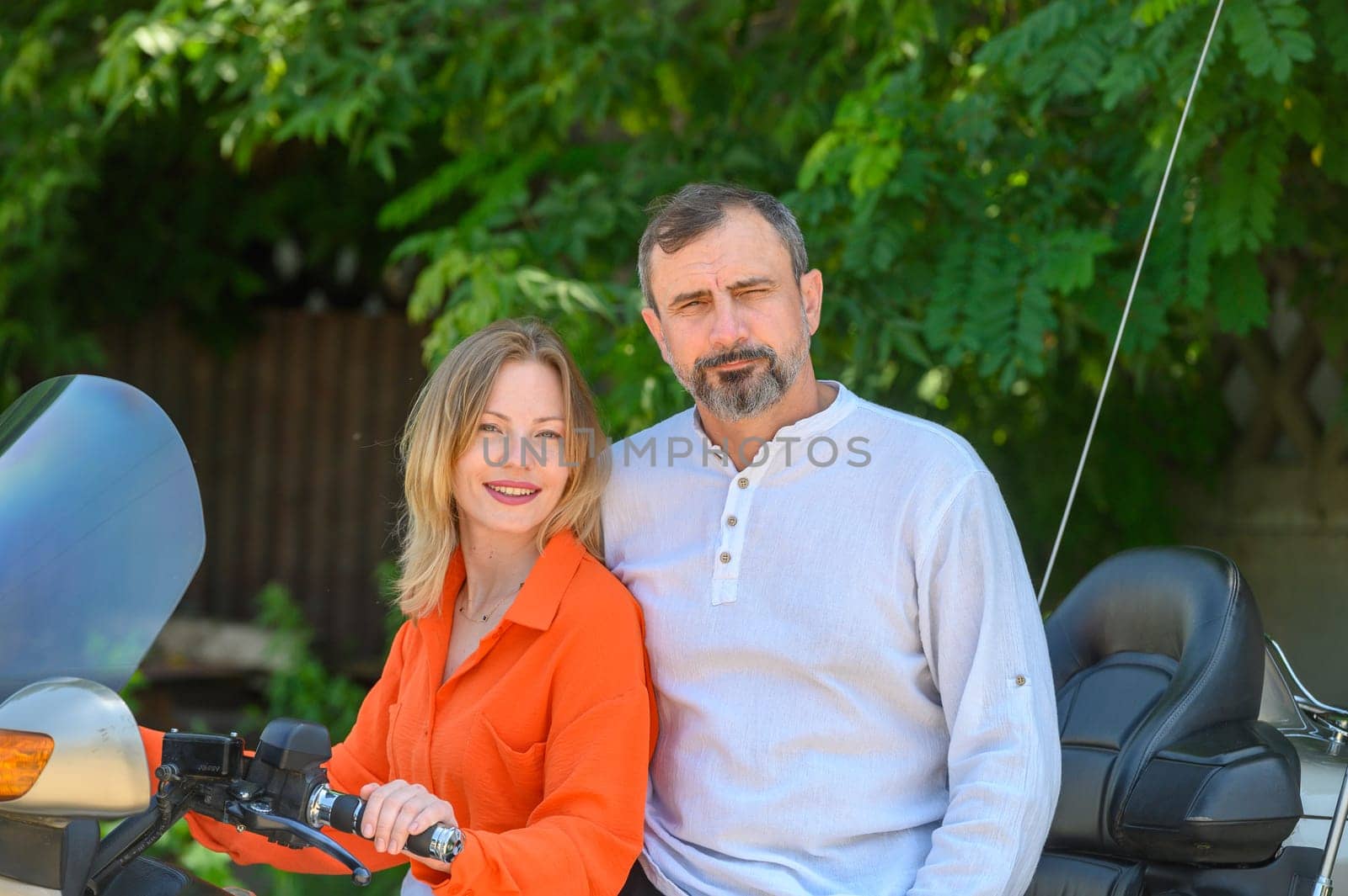 happy husband and wife near a motorcycle