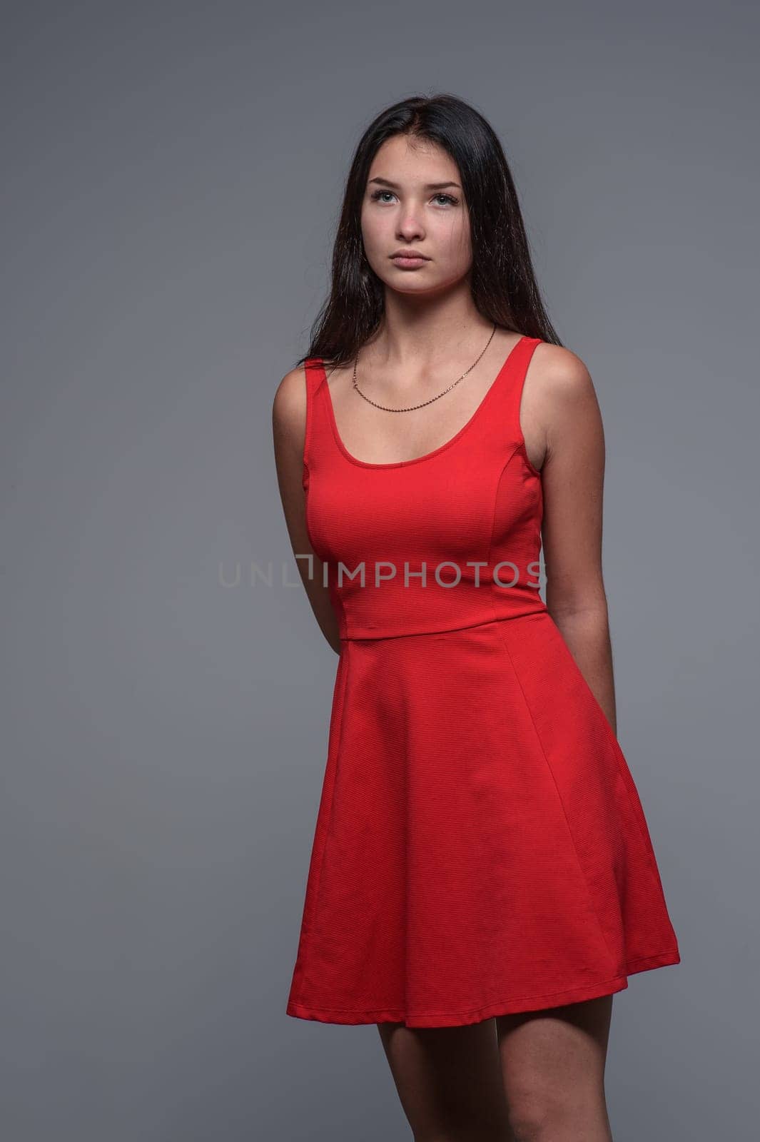 Studio portrait of a young beautiful girl in a red dress