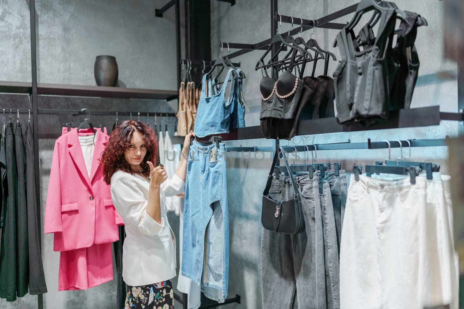 Shopping woman, women's fashion clothes in a store, boutique. Woman choosing clothes in a store by Matiunina