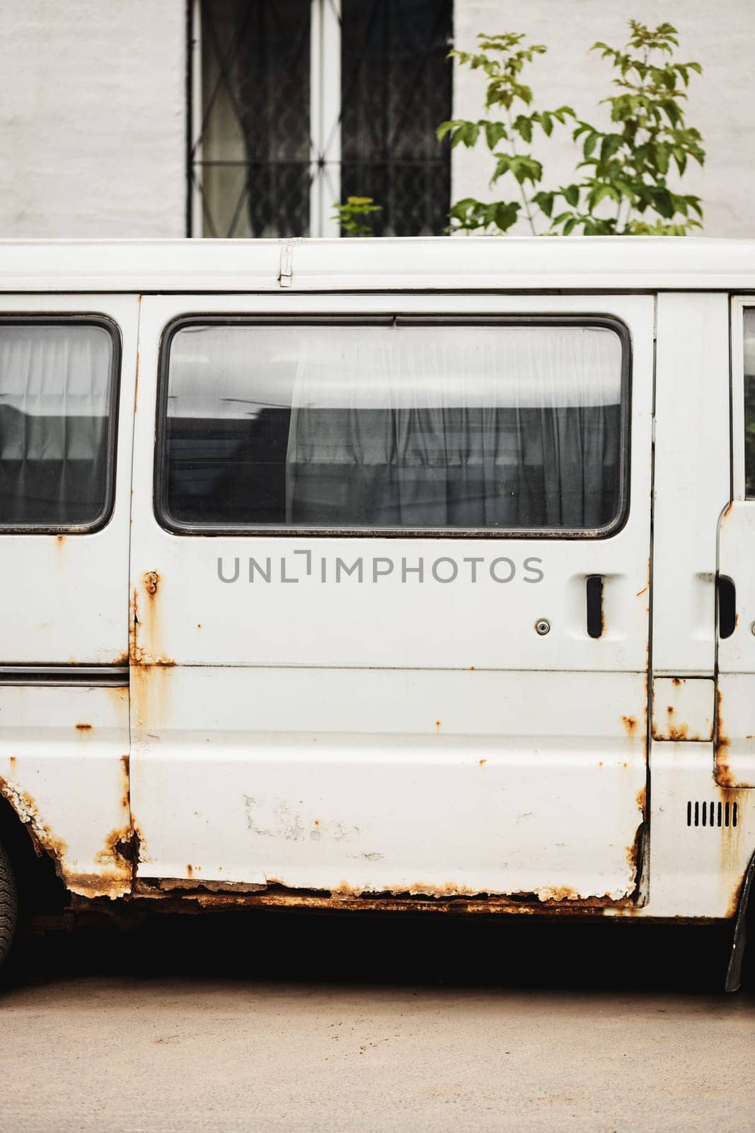 Old rusty white van. Old, rusty, damaged and abandoned mini bus