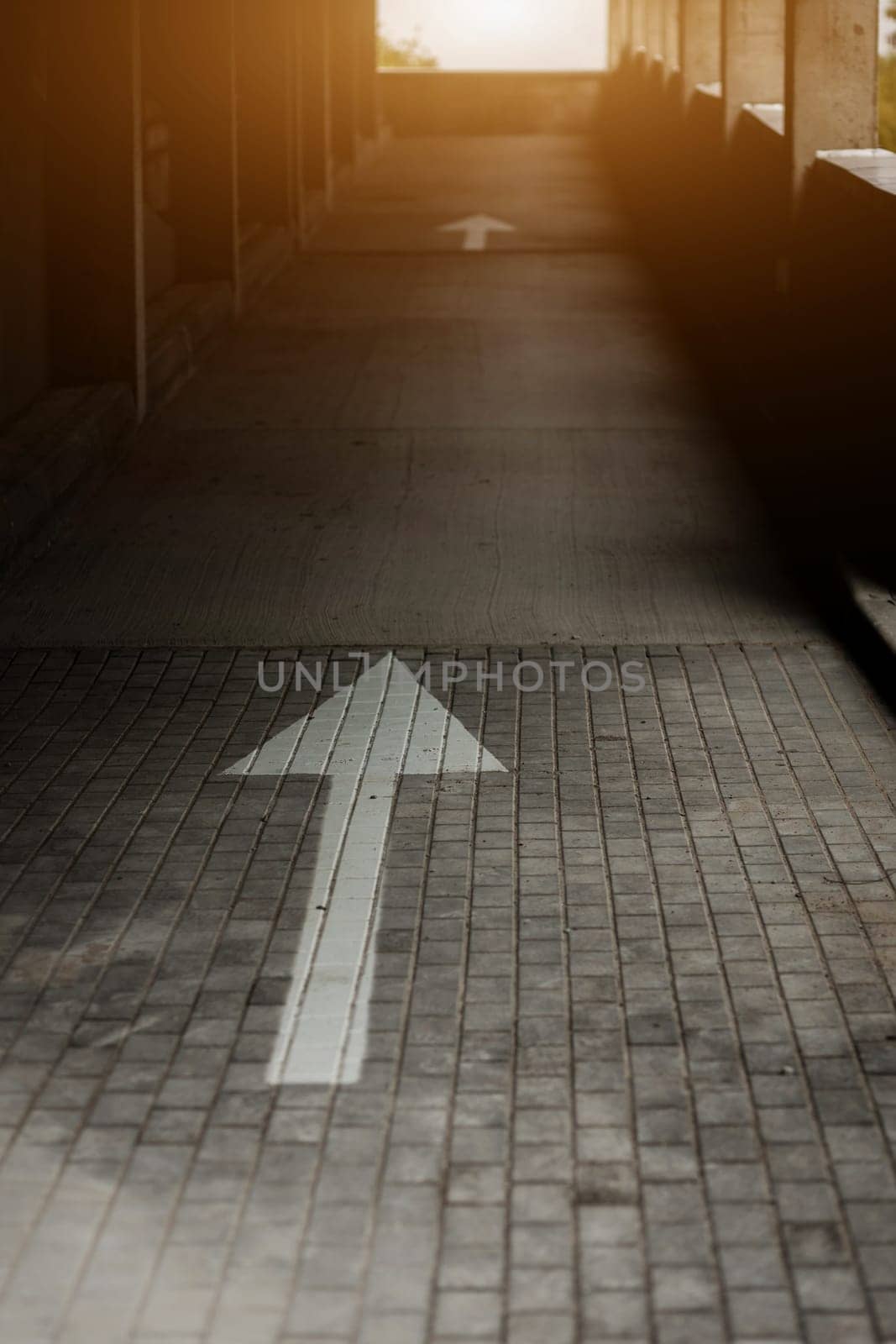 arrow sign on the parking lot. the direction of movement of cars in the garage