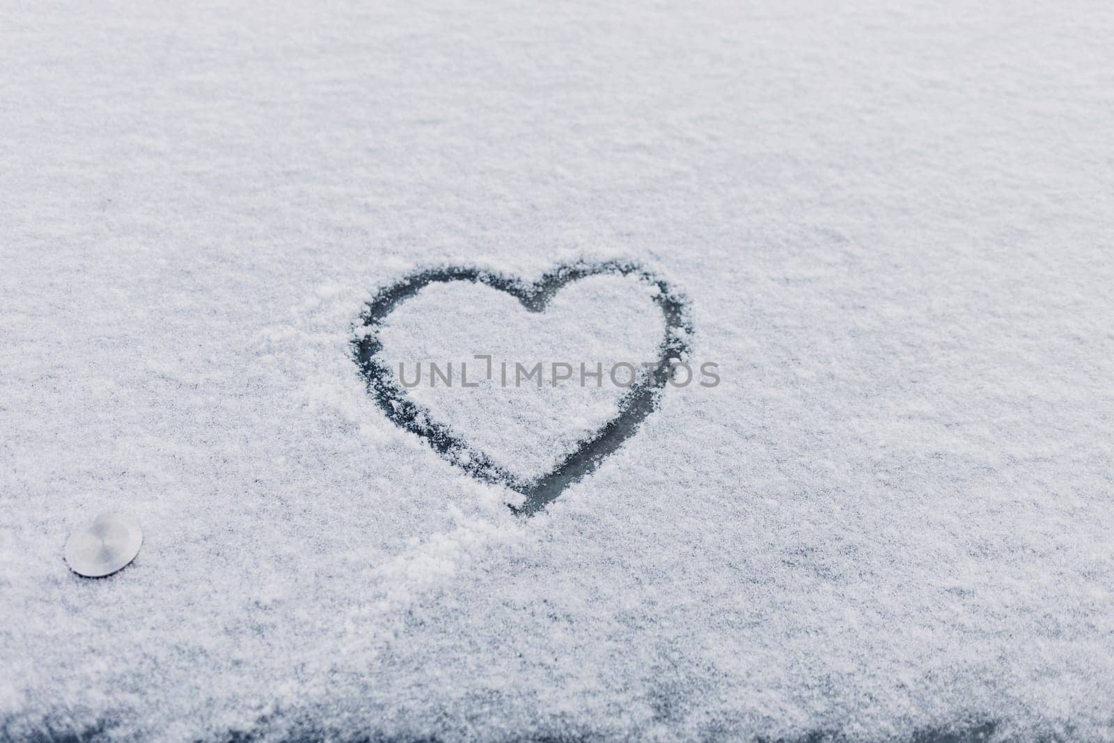 Heart symbol drawn on the snow, on winter day. Romance. Valentine's Day.