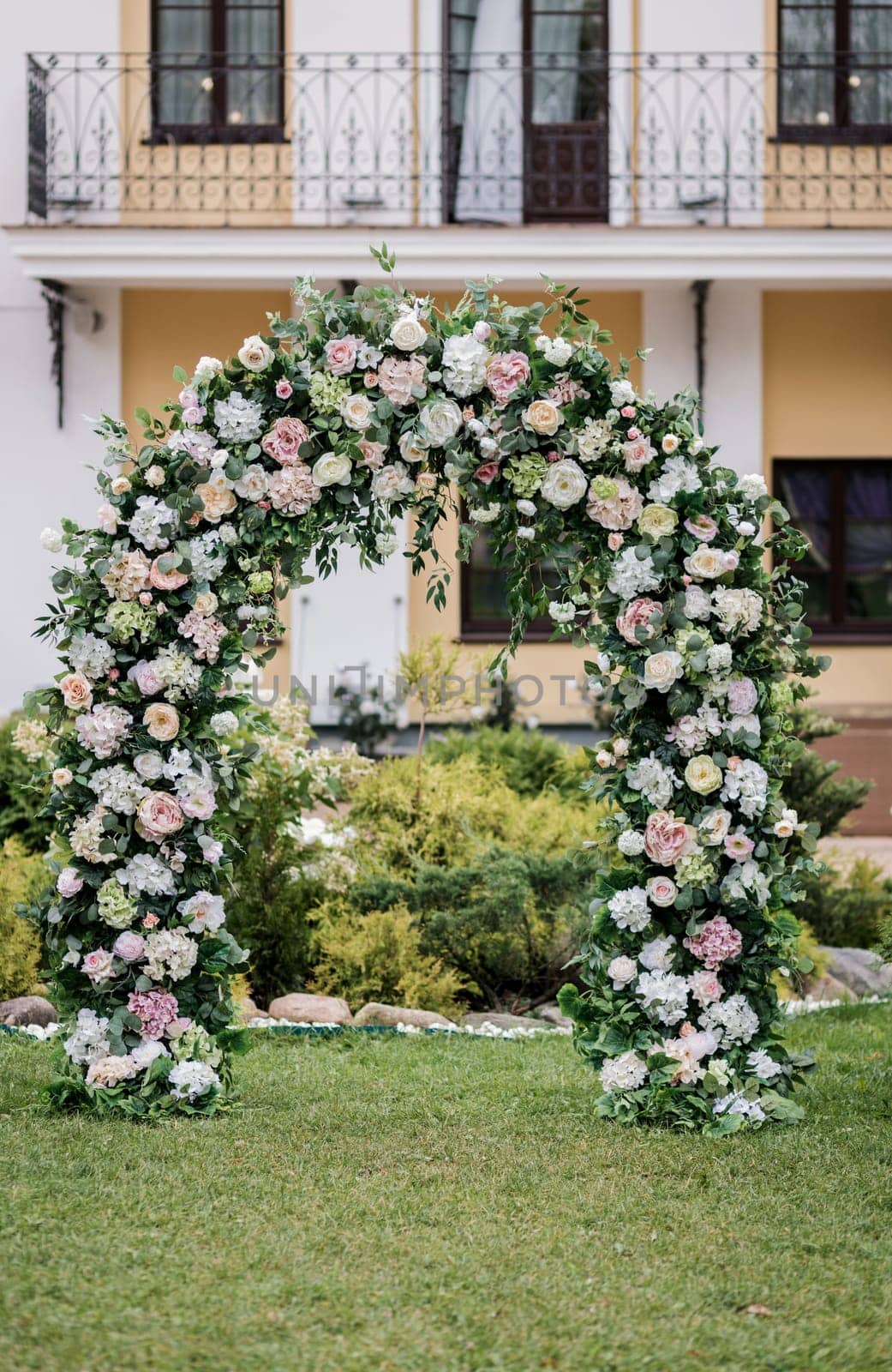 Wedding ceremony. Beautiful wedding arch decorated with flowers, greenery outdoors