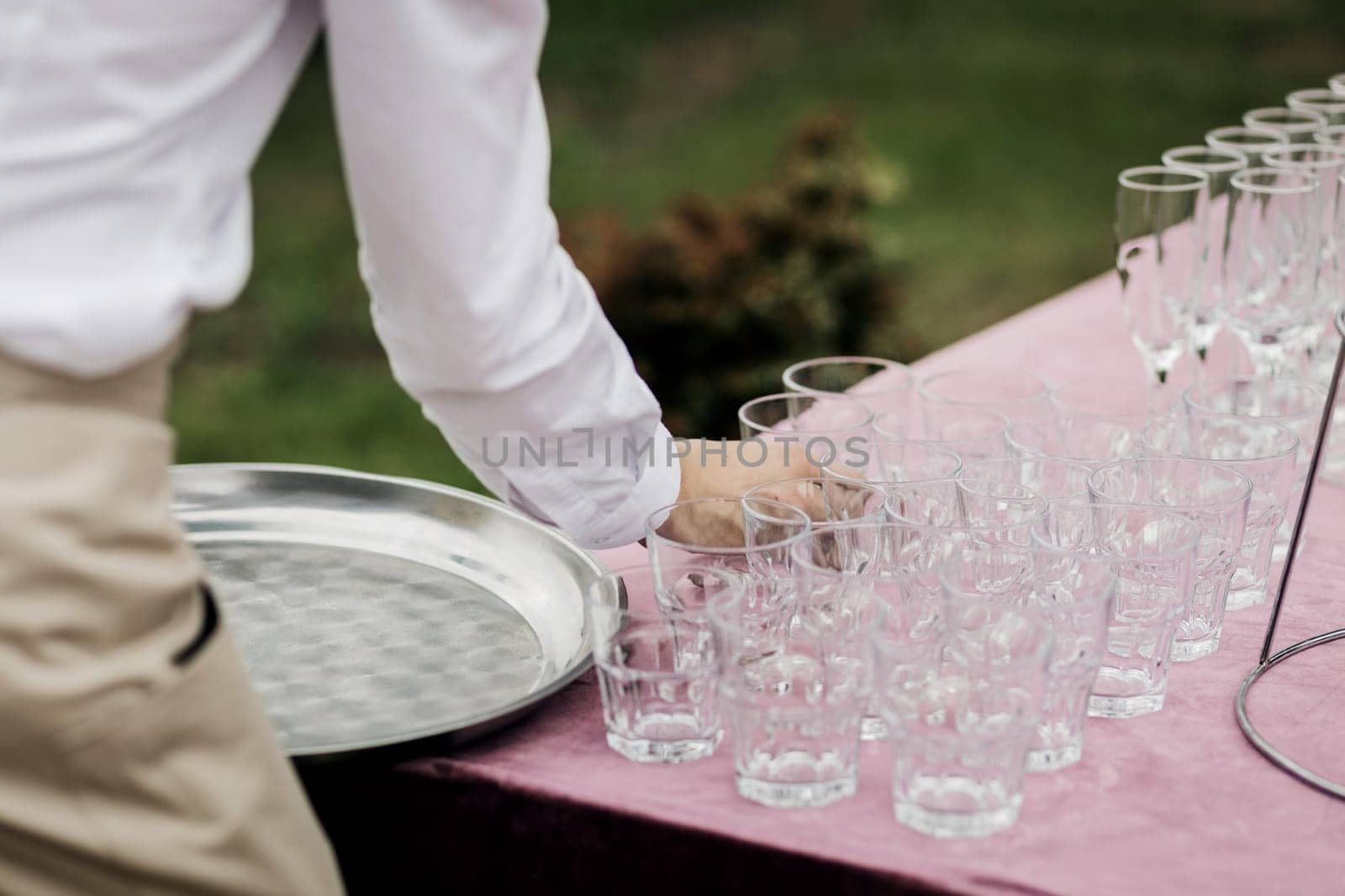 waiter removes empty glasses after a party or wedding