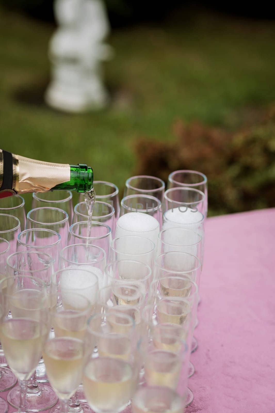 the waiter pours champagne in glasses on the street - wedding catering