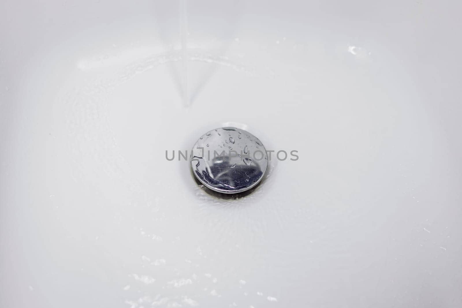 Water flowing down the drain in the washbasin