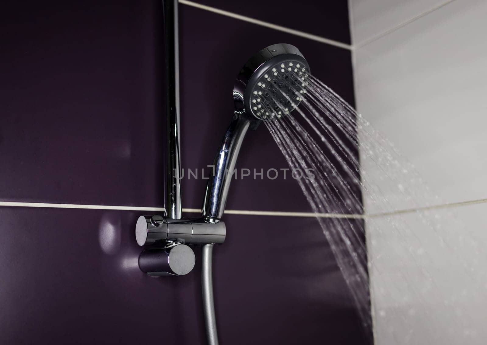 Steel shower head spraying drops down in bathroom. running water of shower faucet