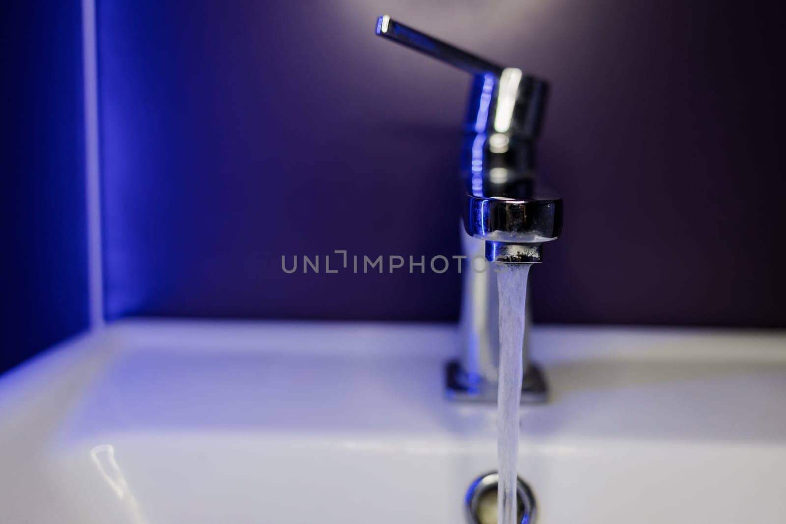 Faucet with flowing water closeup. Silver chrome water faucet 