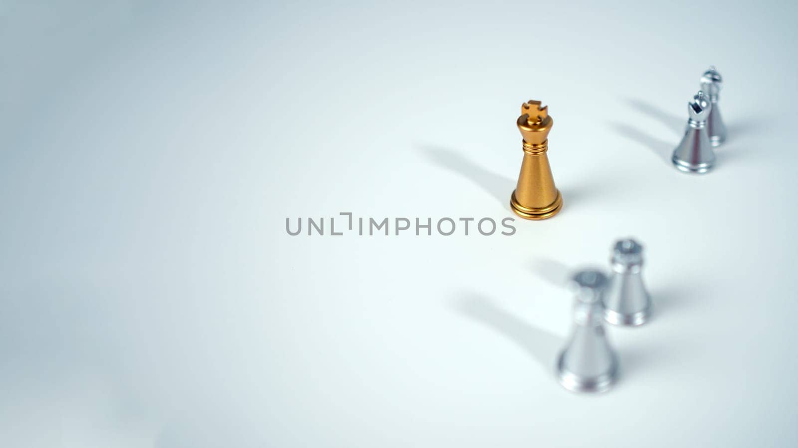 Golden king chess on the board in front of silver chess pieces on white background with copy space, Leadership, fighter, business leadership, competition, confrontation, and business strategy concept.