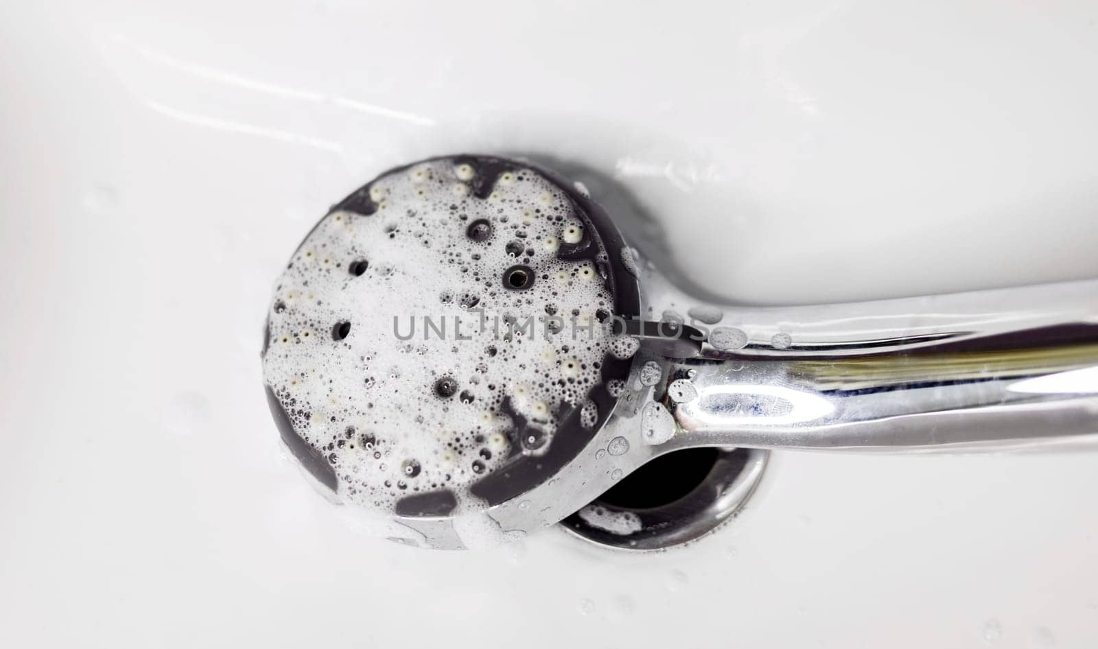 cleaning an calcified shower head with foam in domestic bathroom 