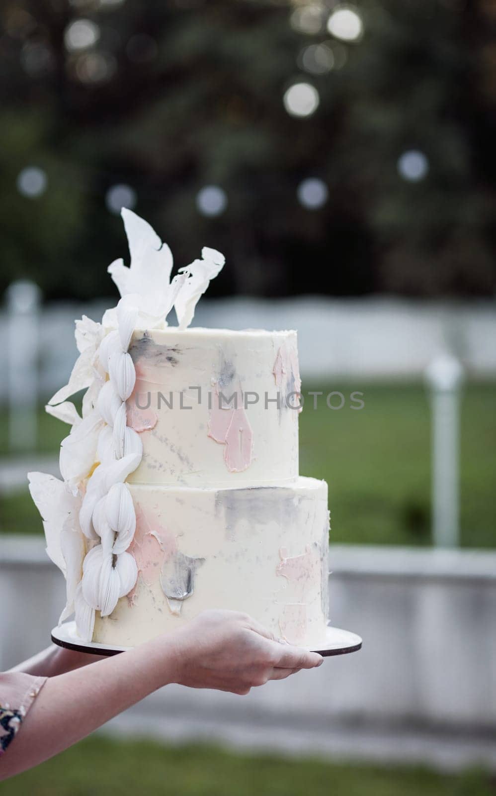 close-up of hands with a wedding cake