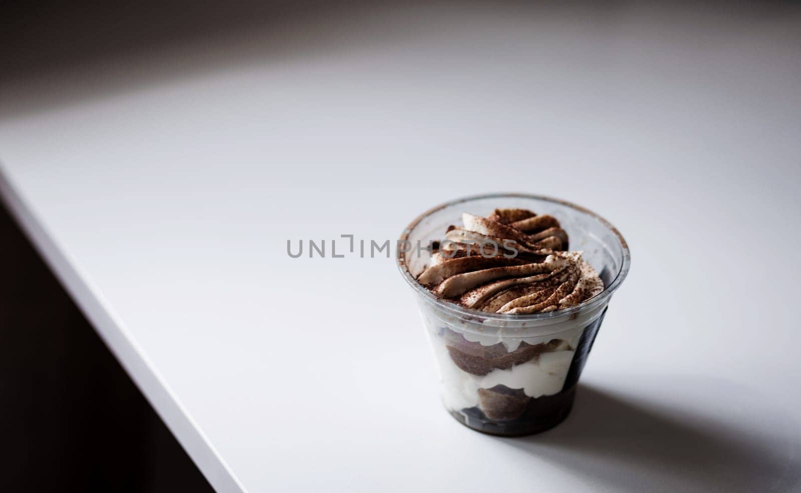 Sweet dessert with chocolate and white airy cream in a transparent glass. 