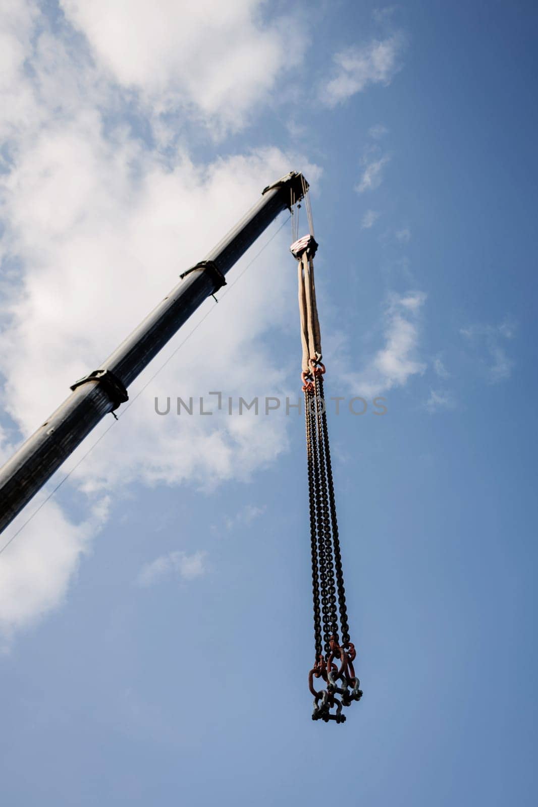 crane boom with hooks on blue sky background