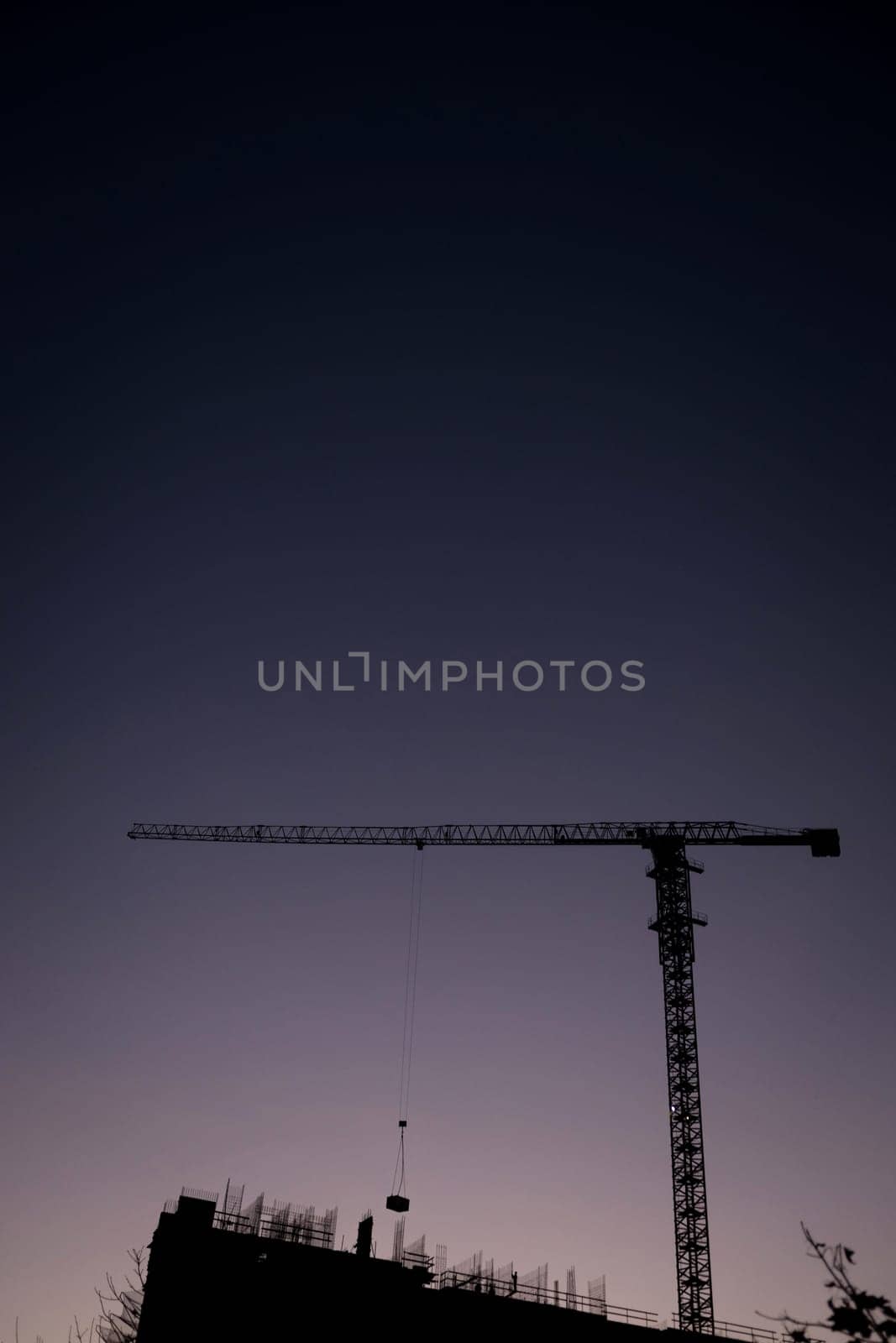 silhouettes of construction at sunset. tower cranes in the dark