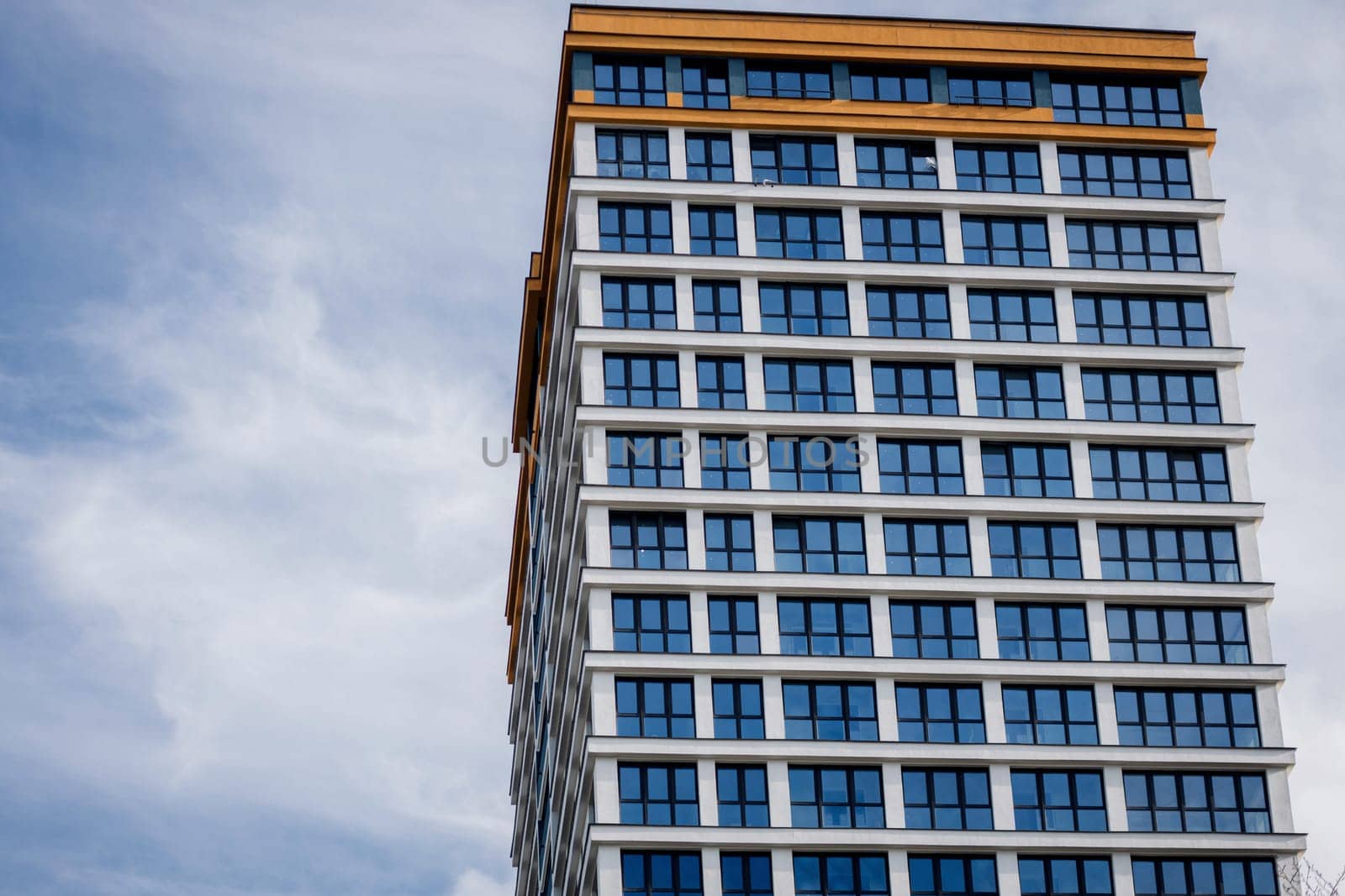 a blue facade with many windows of a residential building against the sky. copy space