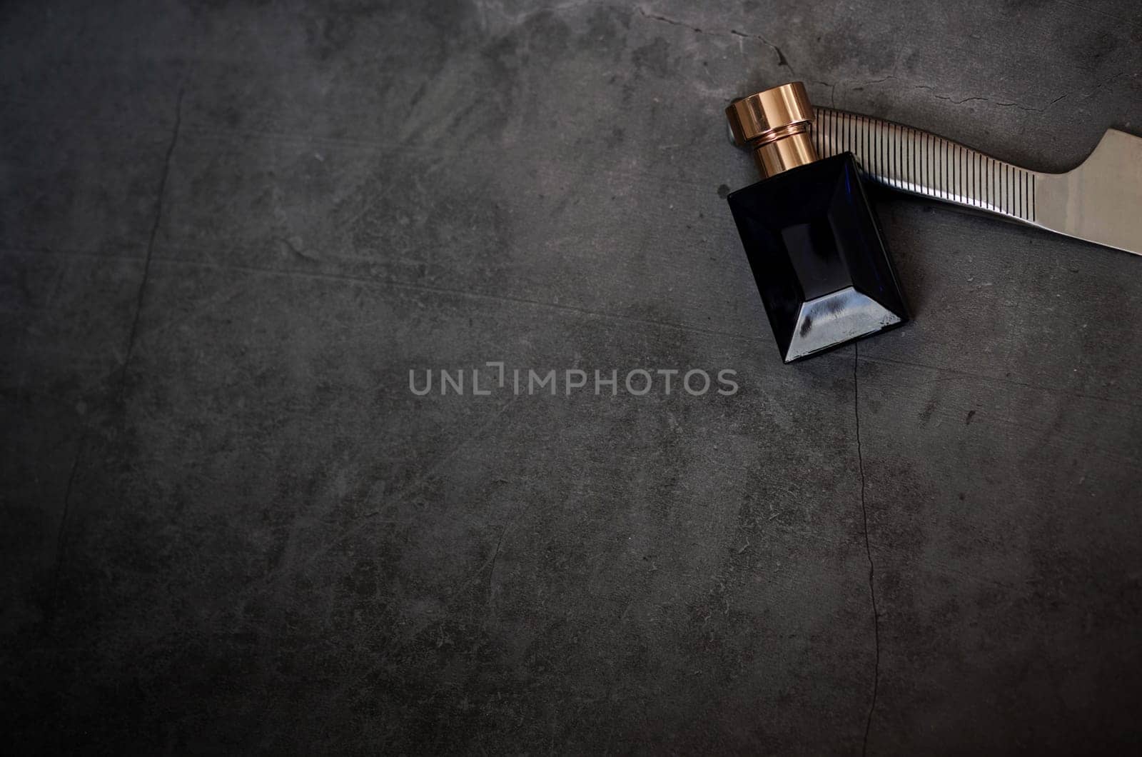 Luxury glass perfume bottle on dark background. Copy space for text, blank bottle