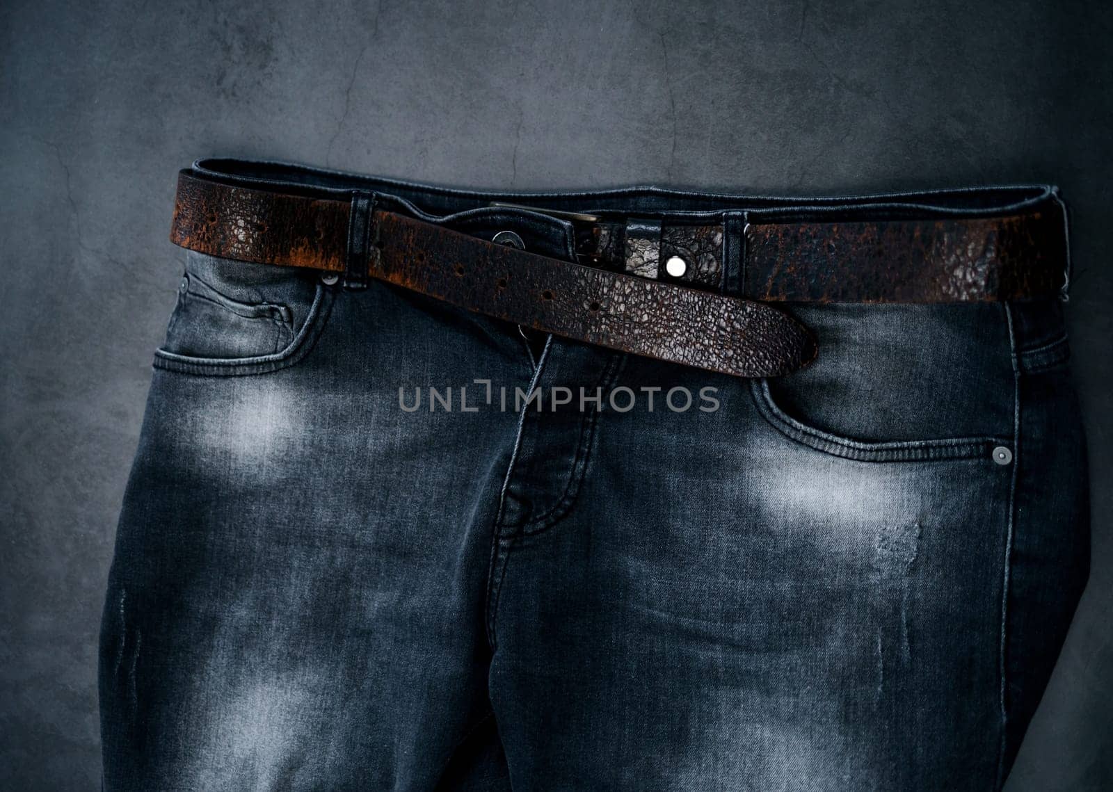 part of black fashion men's jeans with a leather belt. urban style