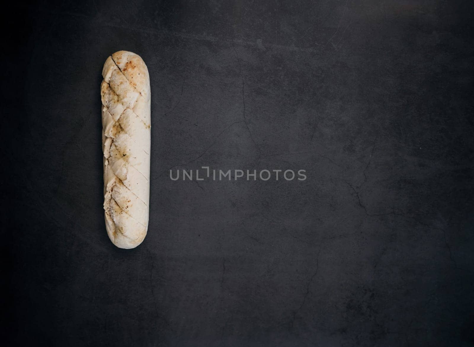Sliced bread over dark stone background. View from above with copy space