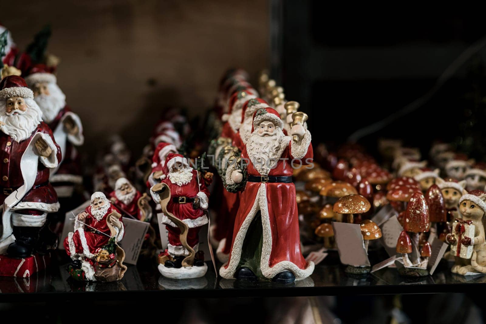  Many toys Santa Claus. Different colorful statuettes of  in souvenir shop. new year and christmas, winter holiday background