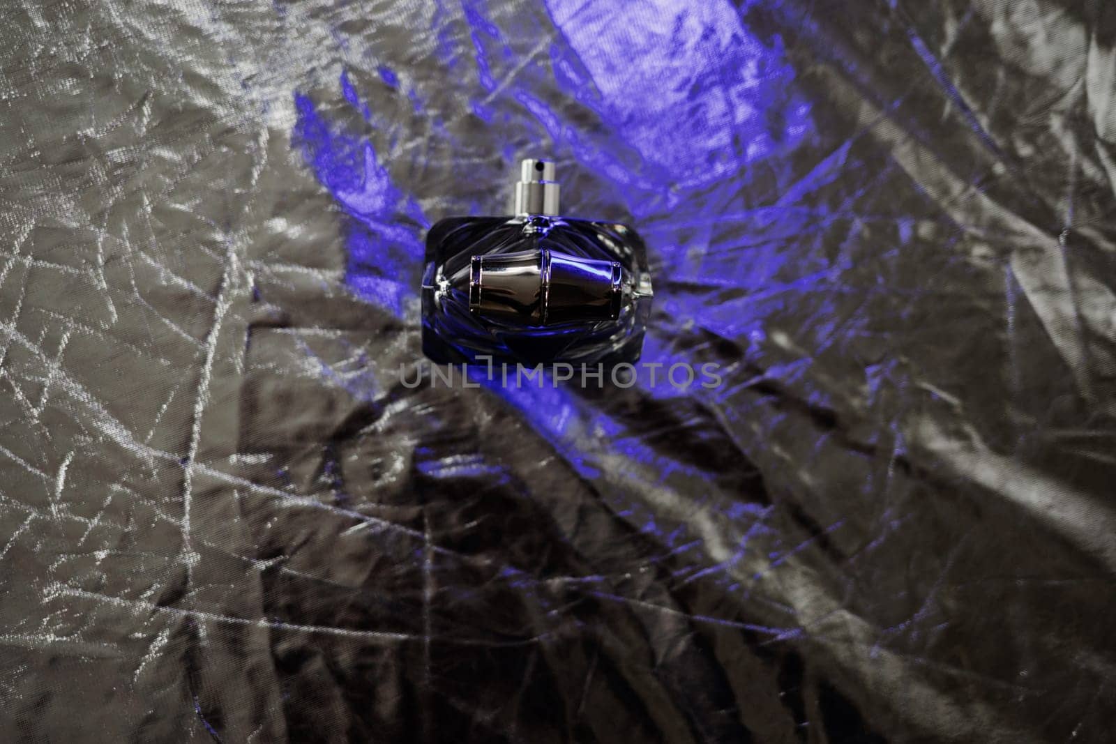 Fashion perfume in glass bottle on silver background. Passionate perfume. 