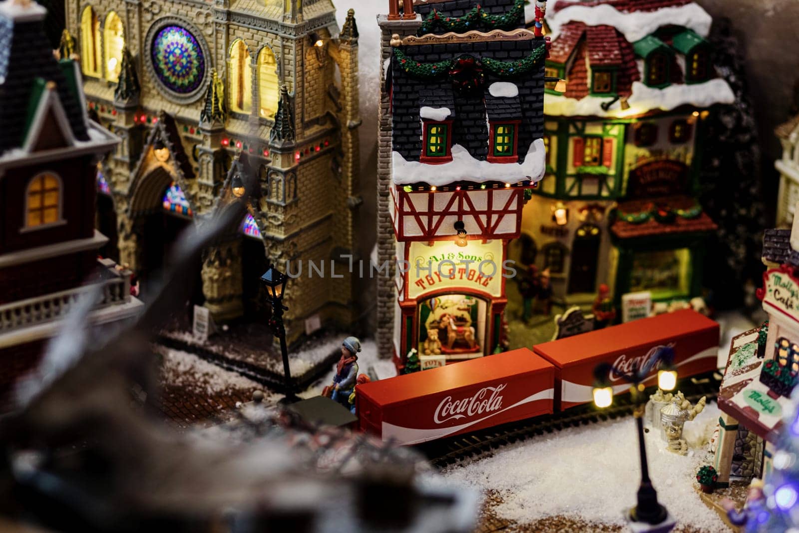 Minsk, Belarus, December 2021 - miniature model of a railway station and train with the Coca Cola logo. Narrow field of focus. Christmas time