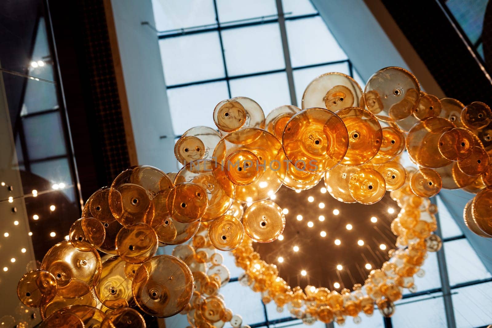 Many large glass lamps hang from the ceiling of the mall