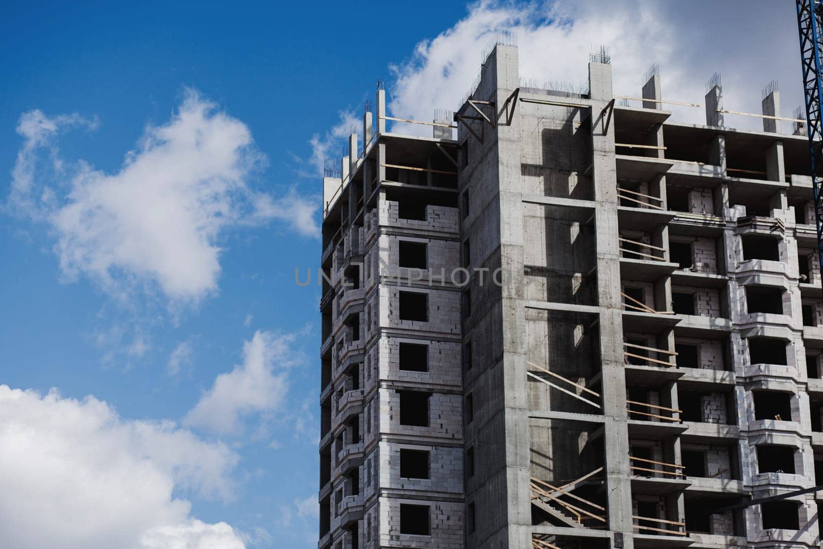 Unfinished cement building on a construction site against the blue sky