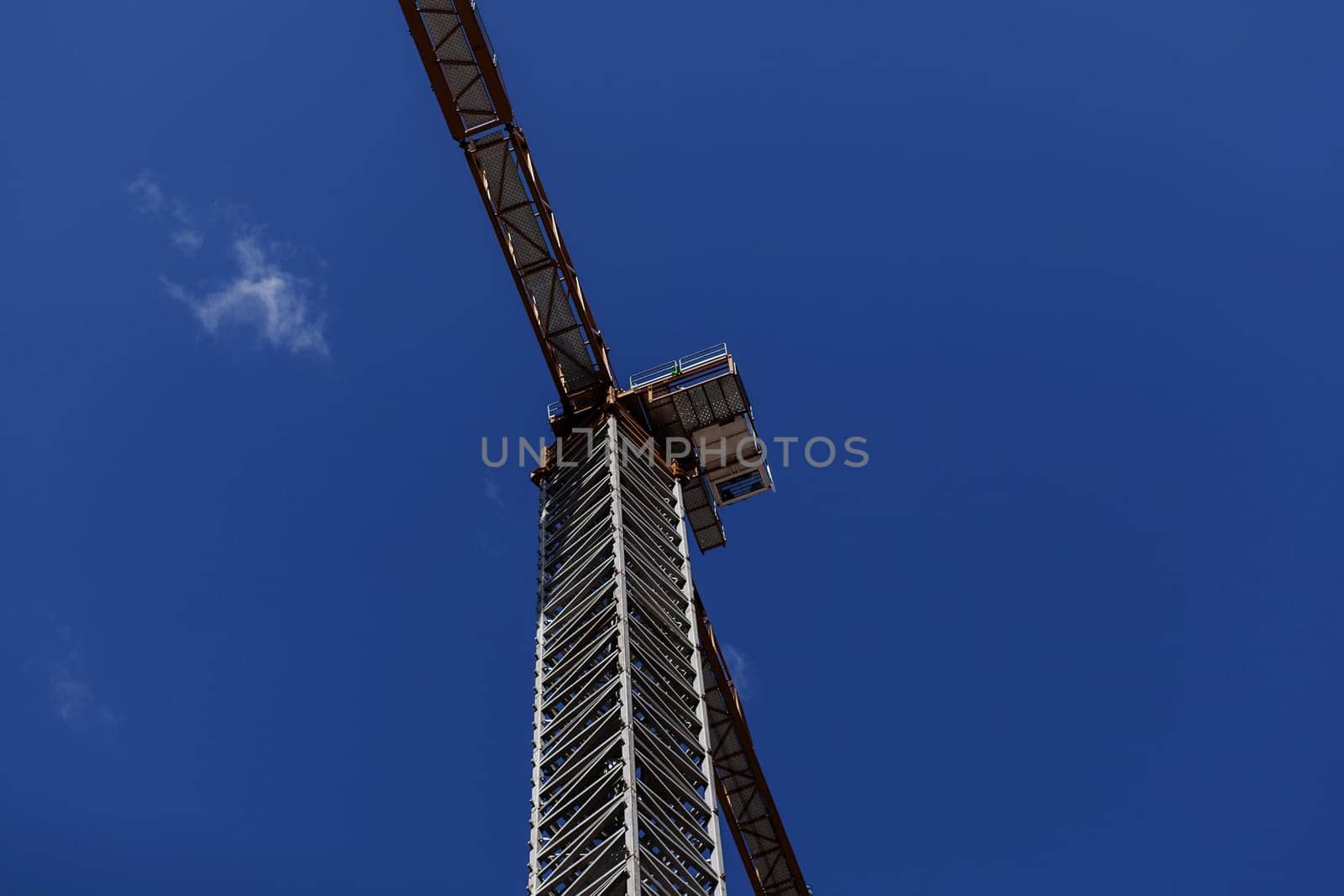 tower crane on the background of the blue sky . Industrial scene