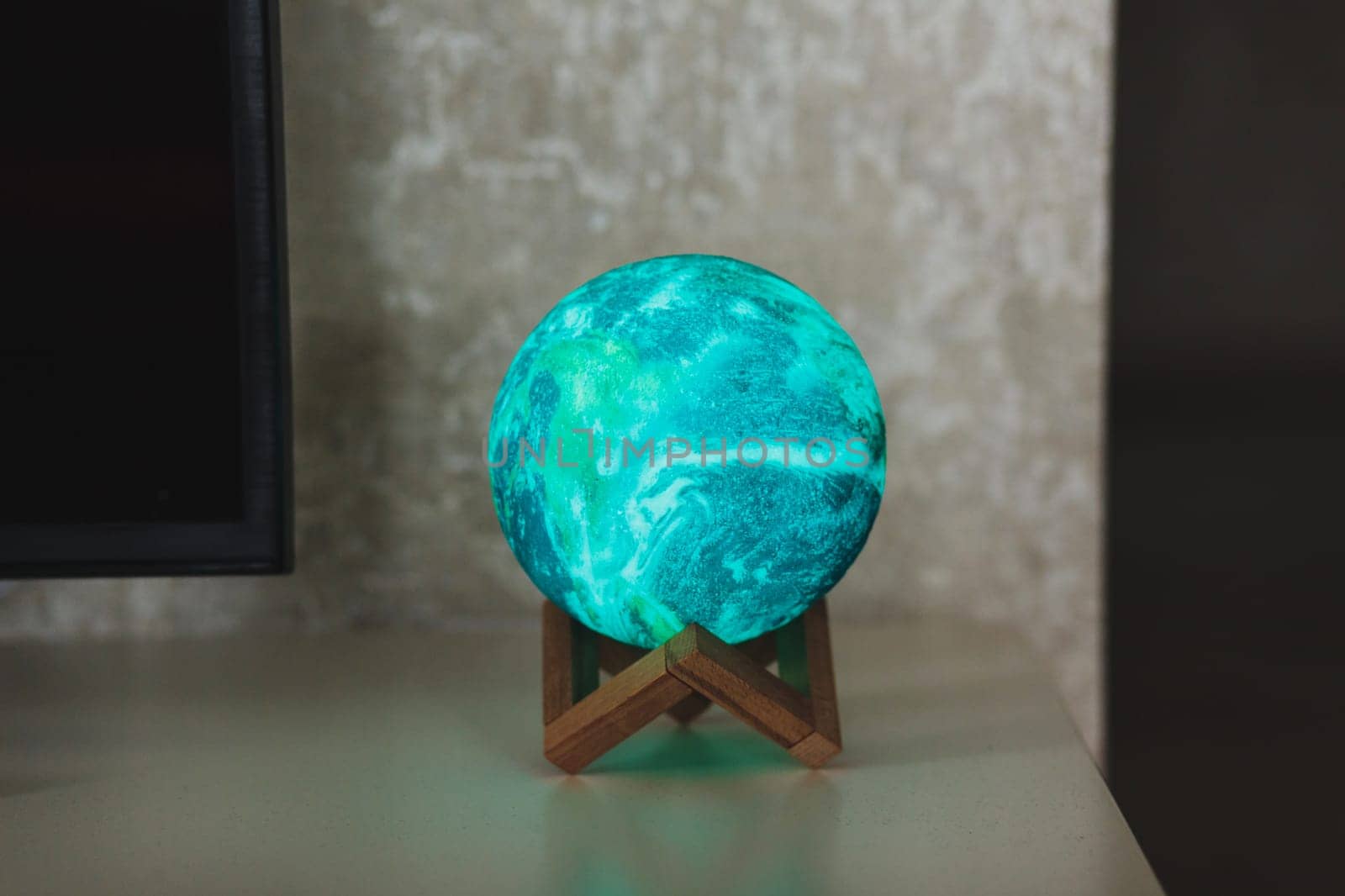 planet or moon lamp stands on the table. round night light