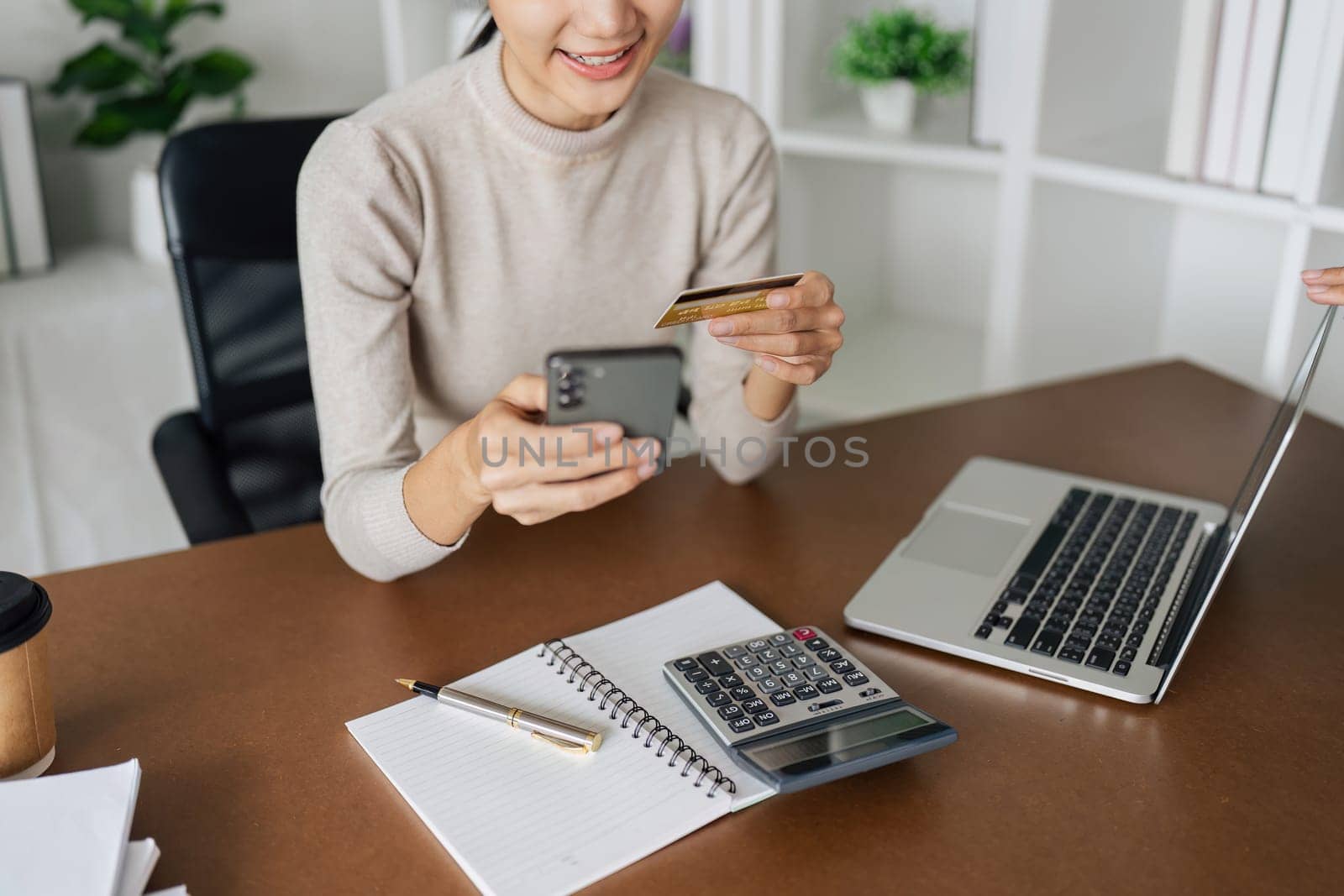 Young woman make a purchase on the Internet on the laptop and mobile with credit card by itchaznong